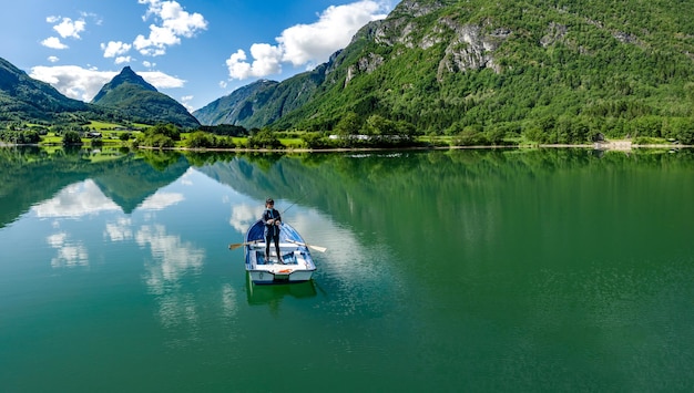 Mulher pescando em um barco. Bela natureza paisagem natural da Noruega. vale de Lodal do lago lovatnet.