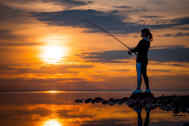 Mulher pescando na vara de pescar girando na Noruega.