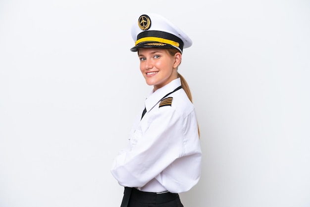 Mulher piloto caucasiana de avião isolada em fundo branco com braços cruzados e olhando para a frente
