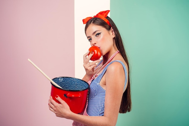 Mulher pin up com maquiagem na moda garota pinup com cabelo da moda mulher retrô cozinhando na cozinha dona de casa perfeita menina bonita em estilo vintage apenas comida saudável