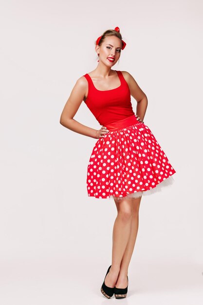 Mulher pin up sorridente em vestido vermelho de bolinhas