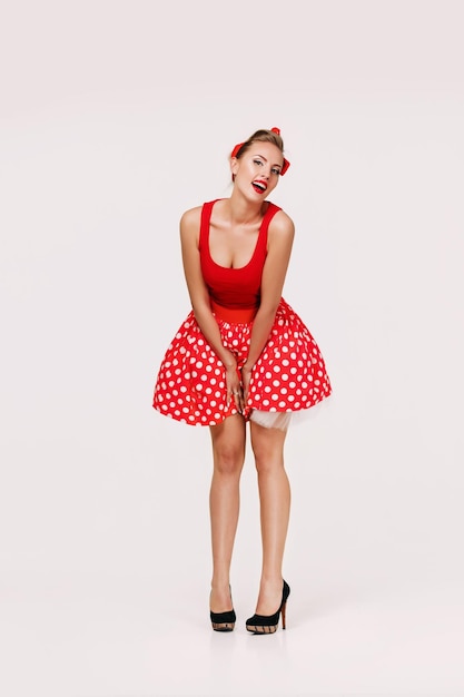 Mulher pin up sorridente em vestido vermelho de bolinhas