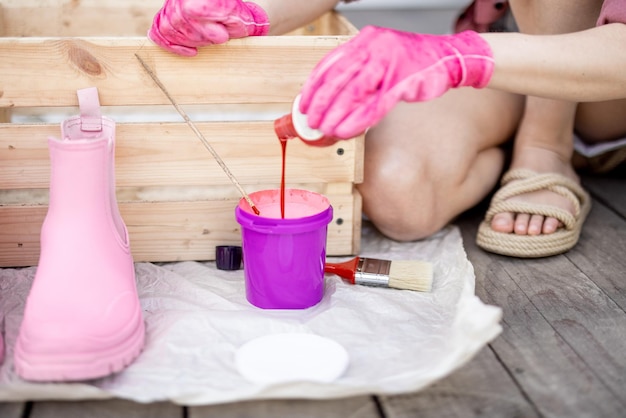 Mulher pintando caixa de madeira em rosa