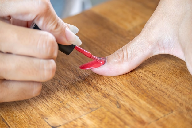 Mulher pintando o dedo grande com esmalte semipermanente