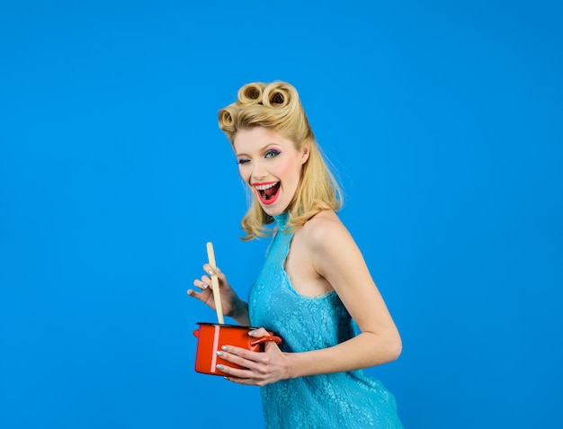 Foto mulher piscando o olho na cozinha com panela e garota pinup de colher de pau com maquiagem fashion