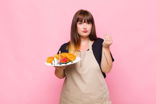 Foto mulher plus size fazendo capice ou gesto de dinheiro, mandando você pagar suas dívidas!