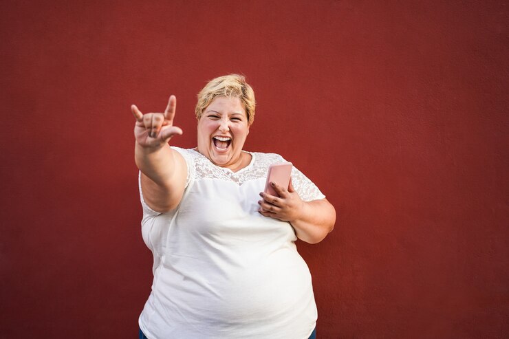 Foto mulher plus size ouvindo playlists de rock no celular - foco no rosto