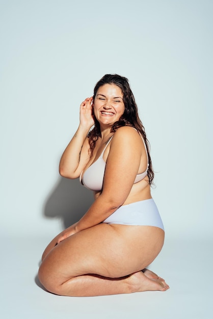 Mulher plus size posando em estúdio em lingerie