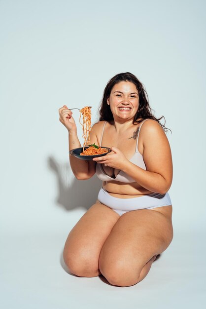 Mulher plus size posando em estúdio em lingerie
