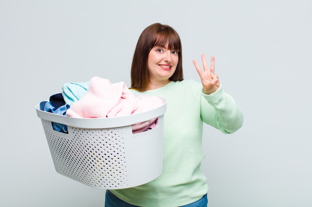 Mulher plus size sorrindo e parecendo amigável, mostrando o número um ou primeiro com a mão para a frente, em contagem regressiva