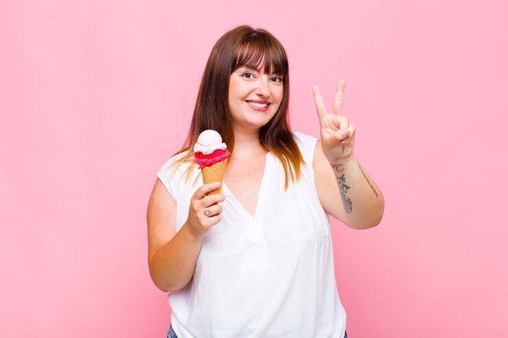 Foto mulher plus size sorrindo e parecendo feliz, despreocupada e positiva, gesticulando vitória ou paz com uma mão