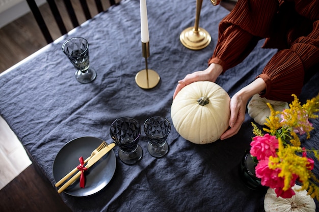 Mulher põe a mesa na véspera das férias de outono