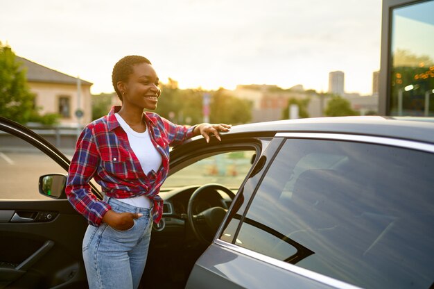 Mulher posa para carro limpo, estação de lavagem automática de mãos