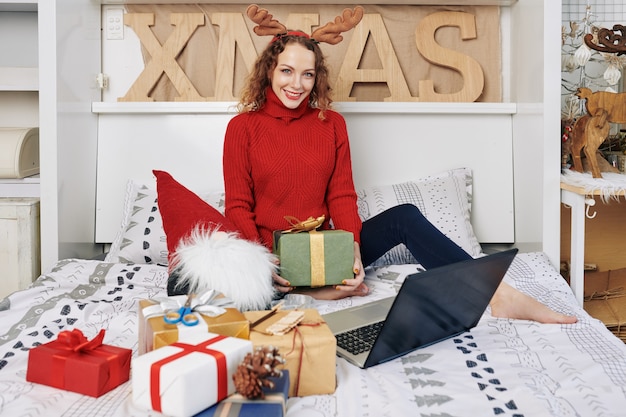 Mulher posando com presentes de Natal