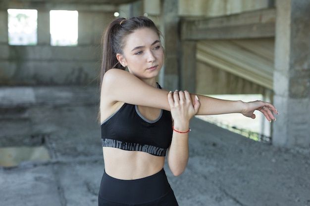 Mulher posando em roupas esportivas no fundo do céu. A parte média do corpo.