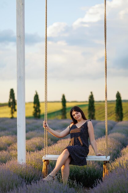 Mulher posando em um balanço em um campo de lavanda