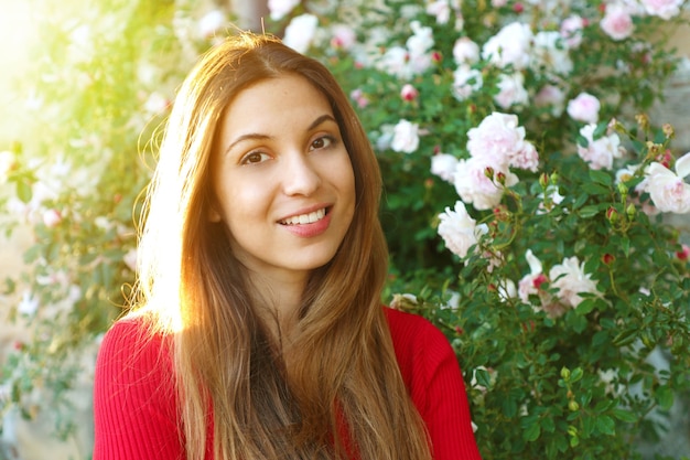 Mulher posando entre rosas em flor