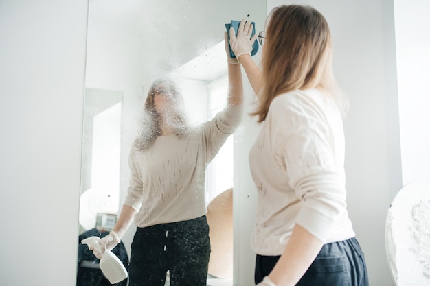 Foto mulher positiva a limpar vidros em casa