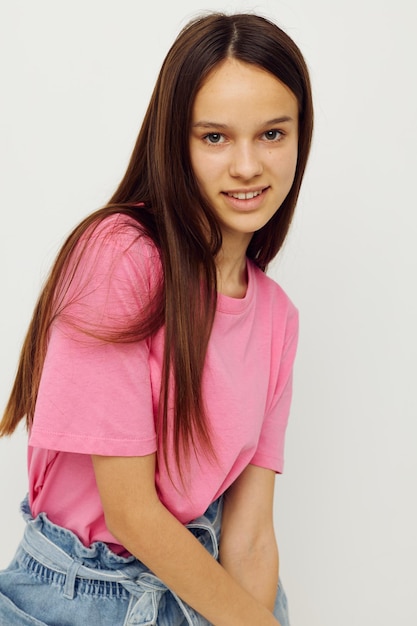 Mulher positiva em uma camiseta rosa roupas casuais fundo rosa