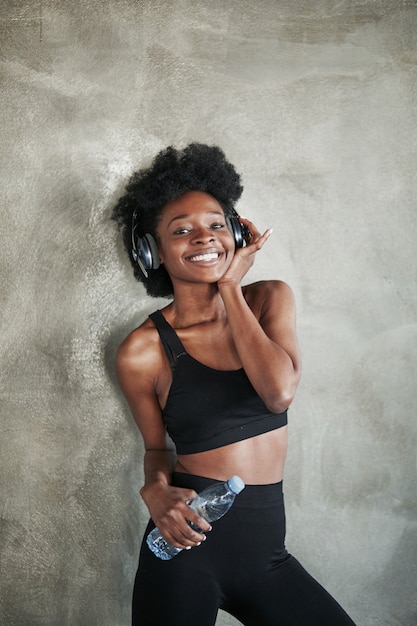Mulher positiva se sente satisfeita. Retrato de uma garota afro-americana com roupas de ginástica, fazendo uma pausa após o treino