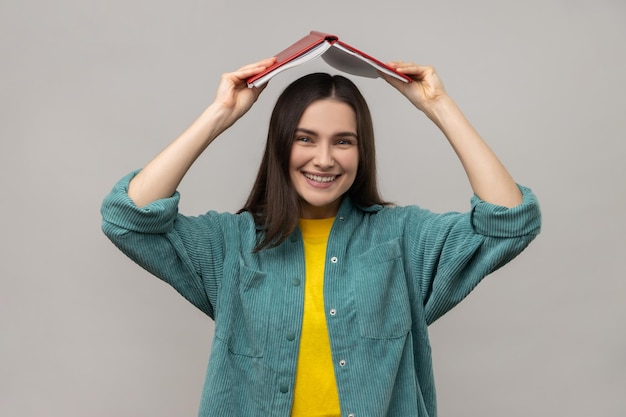 Mulher positiva segurando livro aberto no aluno chefe fazendo ritual para lembrar muito material de estudo