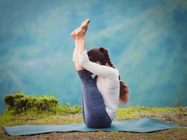 Foto mulher pratica yoga asana urdhva mukha paschimottanasana