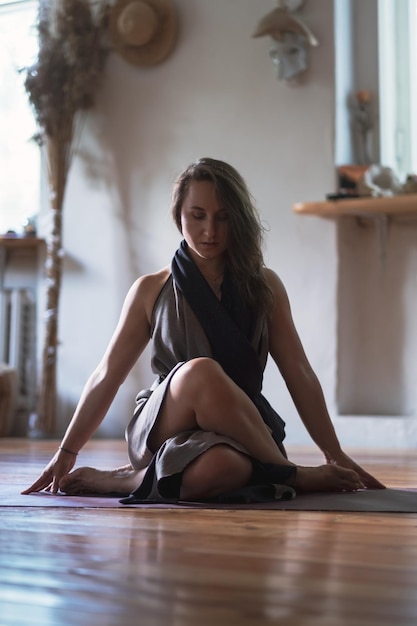 Mulher praticando aula de ioga respirando meditando fazendo gomukhasana