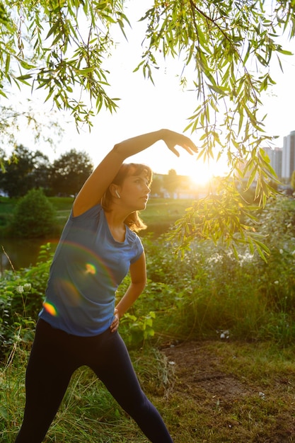 Foto mulher praticando esportes no campo ao pôr do sol