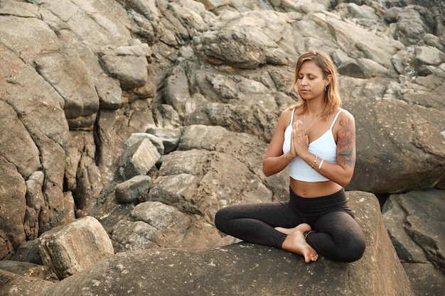 Mulher praticando ioga na natureza. Meditando ao ar livre