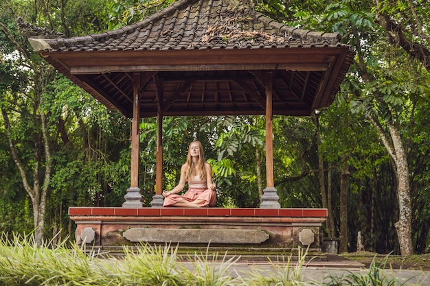 mulher praticando ioga no gazebo tradicional de Bali.