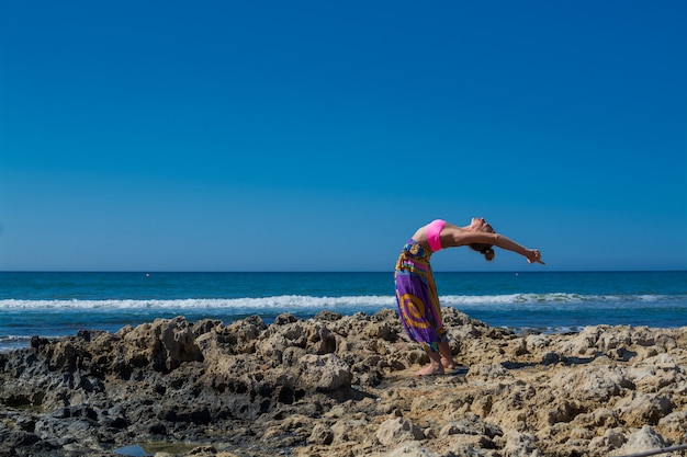 Mulher praticando ioga no mar