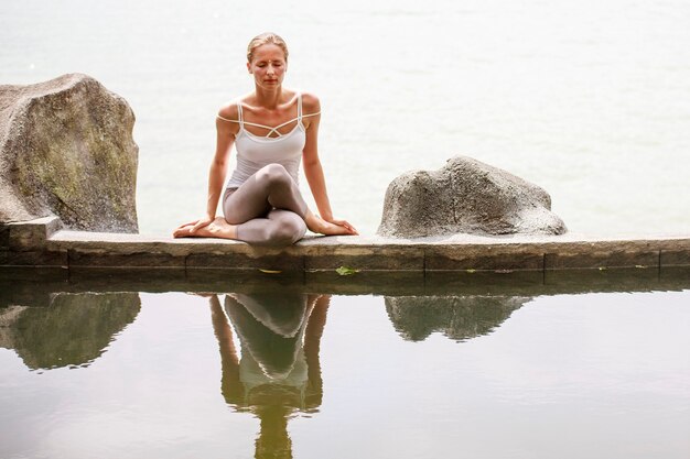 Foto mulher praticando ou fazendo meditação matinal ioga na natureza na praia