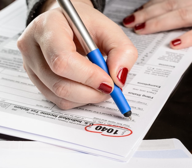 Mulher preenche formulário fiscal trabalhando com documentos fiscais formulário 1040 formulário de declaração de imposto de renda de pessoa física