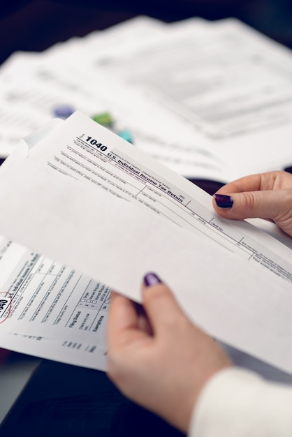 Mulher preenche formulário fiscal trabalhando com documentos fiscais Formulário 1040 Formulário de declaração de imposto de renda de pessoa física