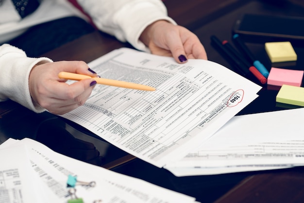 Mulher preenche o formulário fiscal trabalhando com documentos fiscais Formulário 1040 Formulário de declaração de imposto de renda de pessoa física