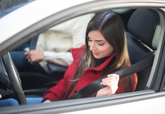 Mulher prendendo o cinto de segurança em seu carro