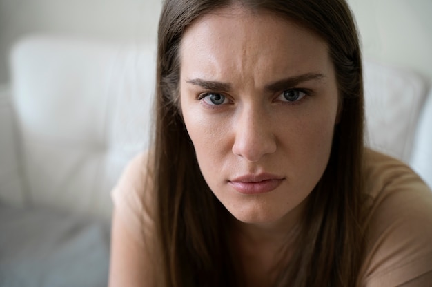 Foto mulher preocupada de alto ângulo no sofá