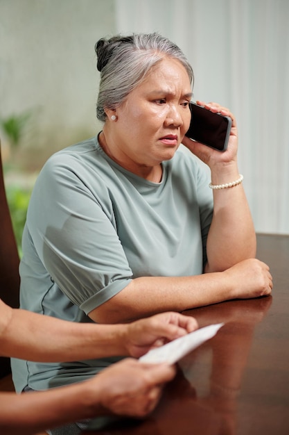 Mulher preocupada, falando no telefone