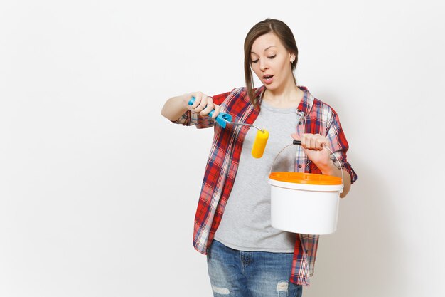 Mulher preocupada segurando rolo de pintura para pintura de parede balde vazio de tinta com espaço de cópia isolado no fundo branco. ferramentas de acessórios de instrumentos para sala de apartamento de renovação. conceito de casa de conserto