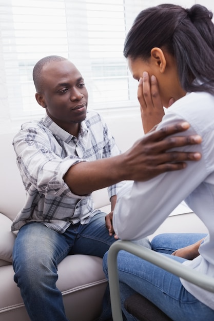 Mulher preocupada sendo consolada por seu terapeuta