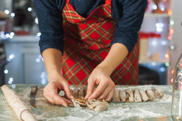 Mulher prepara biscoitos de natal em casa na cozinha cozinhando caseira