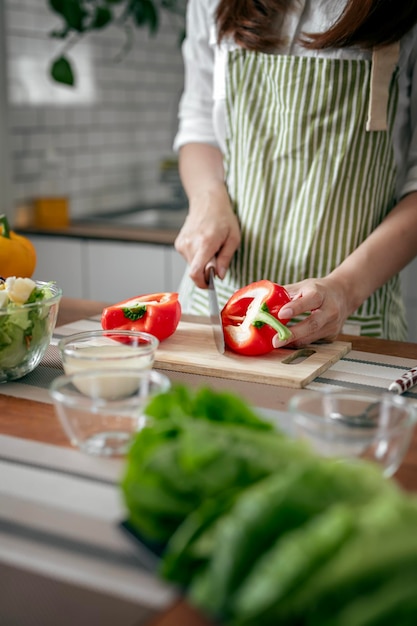 Mulher prepara comida saudável de legumes frescos e frutas na sala de cozinha