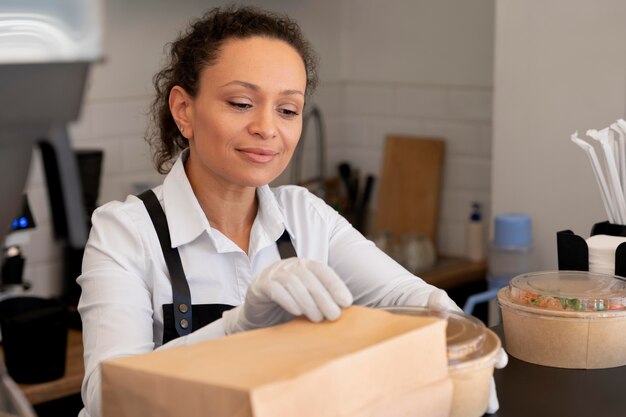 Mulher preparando comida para viagem para ser entregue