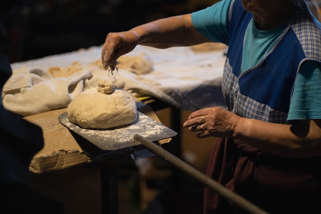 Mulher preparando e cortando pão