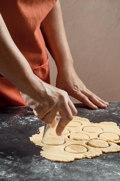 Foto mulher preparando massa para biscoitos caseiros na mesa da cozinha