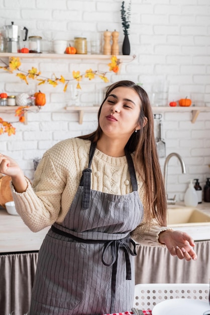 Mulher preparando o jantar de ação de Graças na cozinha de casa