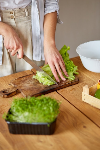 Mulher preparando salada de legumes na cozinha