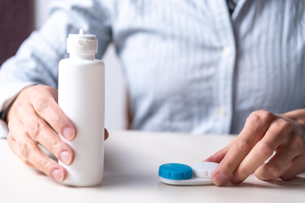 Mulher preparando seu espaço de lentes de contato para copiar miopia e foco seletivo de conceito de visão de astigmatismo