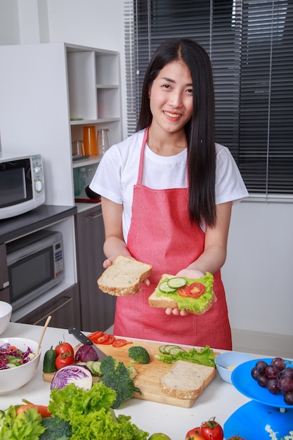 mulher preparando um sanduíche na cozinha