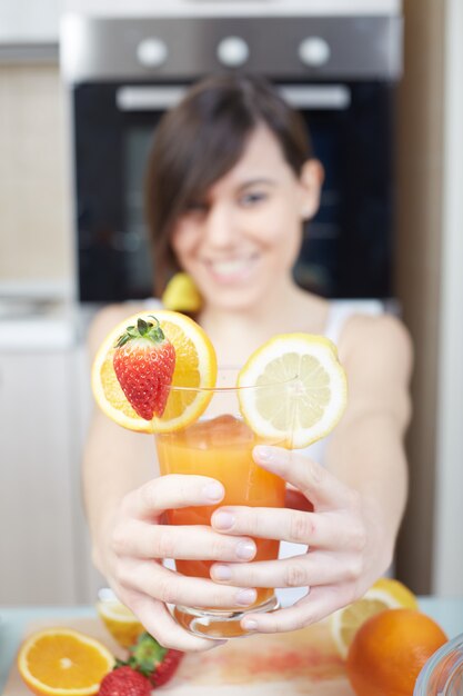 Mulher preparar um suco de fruta com espremedor